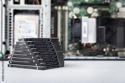 Closed-up view of SSD hard disk drives with a PC in the background. Upgrade, repair and data recovery concept