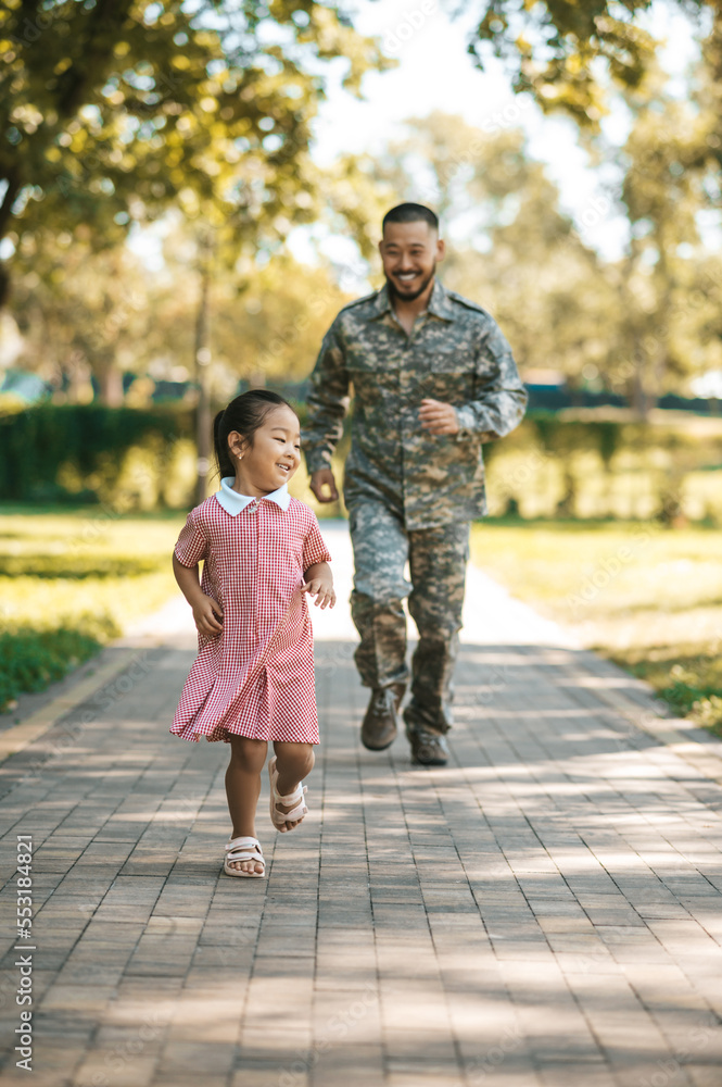 Dad and daughter having fun and running in the park Dad and daughter having fun and running in the park