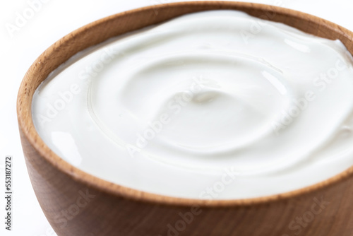 Greek yogurt in wooden bowl isolated on white background. Creamy natural yogurt