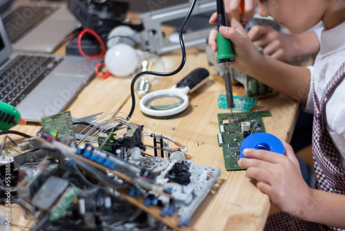 Wallpaper Mural Close-up of girls hands with solder. School boy and girls learning how to assemble circuit board. School classes, hobby, robotics concept Torontodigital.ca