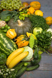 A large pile of vegetables and fruits on a wooden background