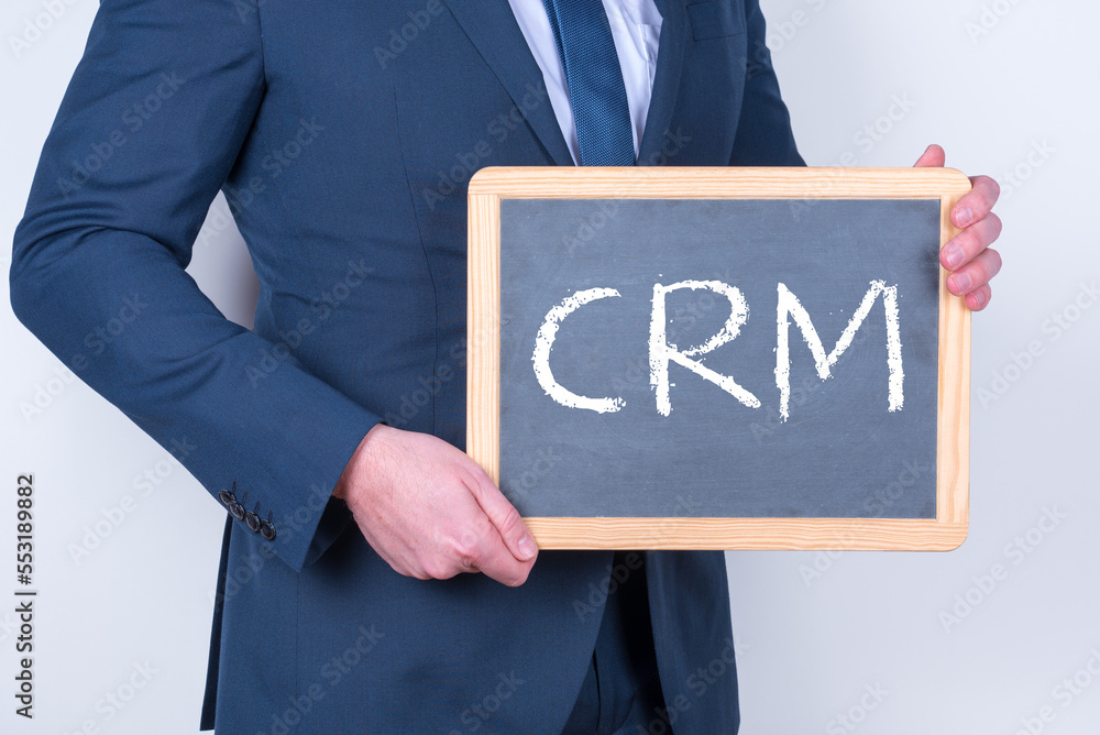 Vertriebsmitarbeiter mit einer Tafel auf der CRM steht