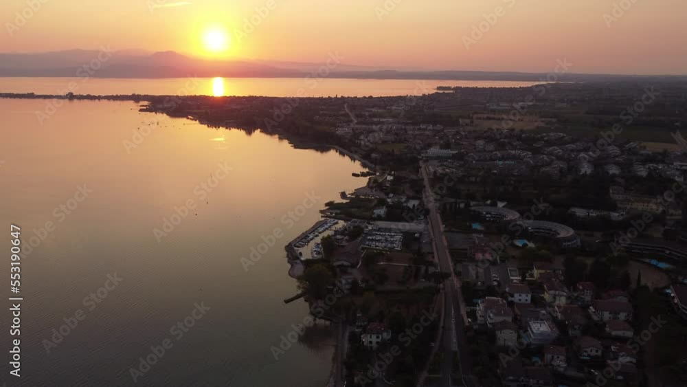 Aerial shot of Lake Garda at sunrise with mountains in the back Aerial shot of Lake Garda at sunrise with mountains in the back
