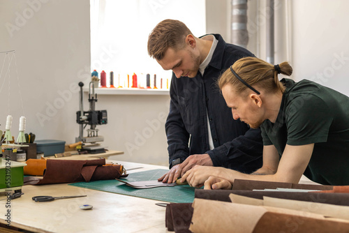 Fotografie Craftsman unwrapping bundle of stuff natural material working at leather workshop