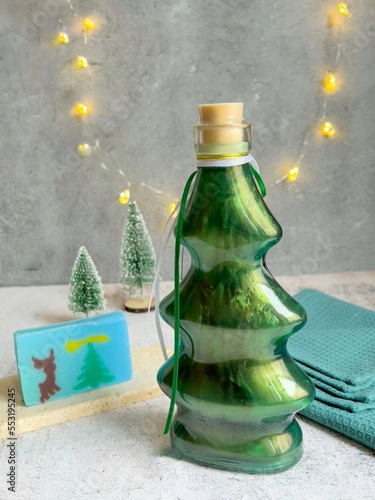 Bath foam in the shape of a Christmas tree, soap and a towel. Decorative design.