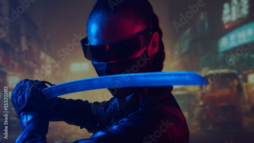Cyberpunk ninja girl in a mask and with a katana. Beautiful female samurai woman on the background of Asian city downtown. © Acronym