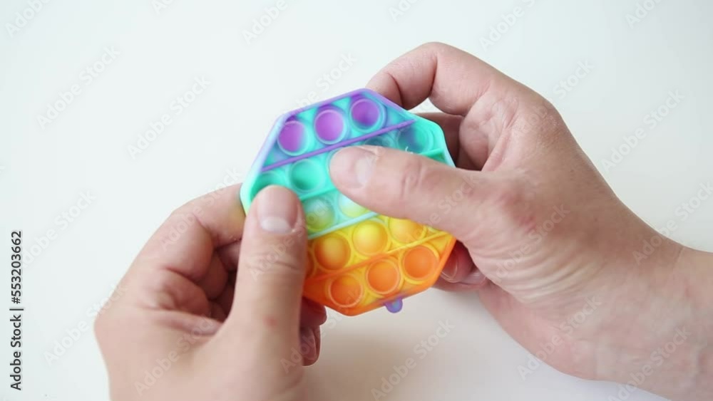 Hands with psoriasis-affected skin press the bulges on the antistress rubber toy - popit. Colorful sensory toy fidget push pop it in kids hands. Finger push color anti-stress game with bubbles Hands with psoriasis-affected skin press the bulges on the antistress rubber toy - popit. Colorful sensory toy fidget push pop it in kids hands. Finger push color anti-stress game with bubbles