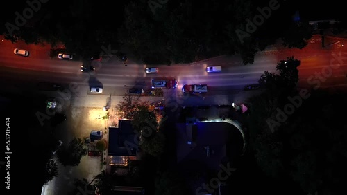 Aerial shot of a firebrigade blaring horn and rushing through traffic. Fire trucks crossing intersection in the night. Fire truck crews. Aerial photo
