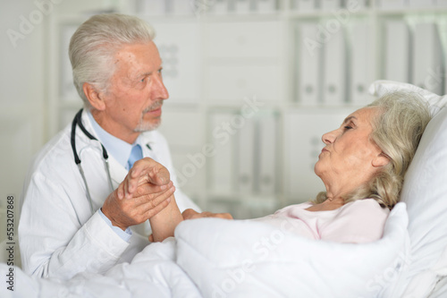 old woman portrait in hospital with caring doctor