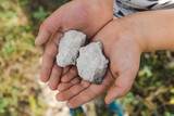 child holding small pieces of limestone in his hands