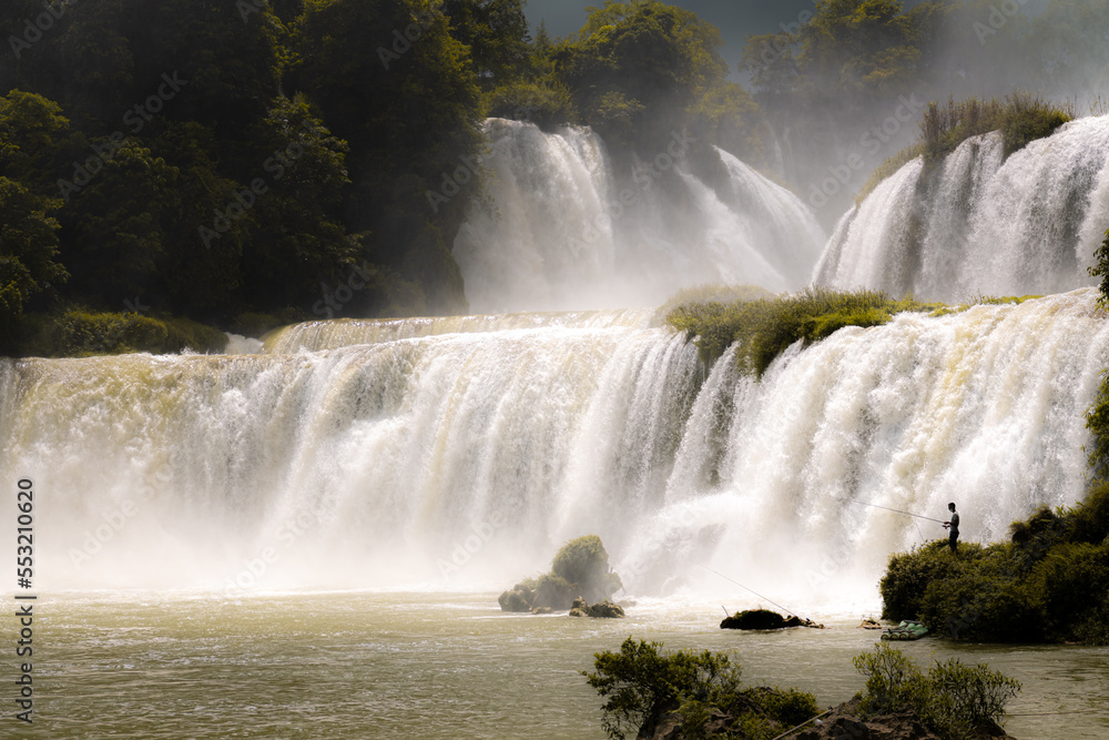 Fototapeta premium Gorgeous Detian Falls in Guangxi, China and Banyue Falls in Vietnam with fisherman 