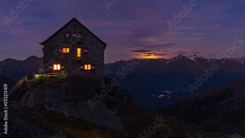 Full moonrising above alpine ridge behind the hut