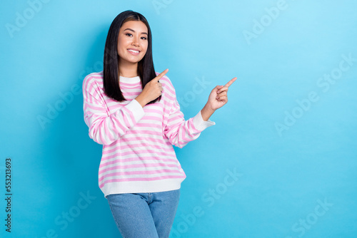 Photo of pretty cheerful girl dressed pink pullover pointing fingers empty space isolated blue color background