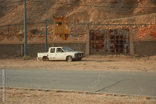 wrecked abandoned white pickup on the side of the road photo