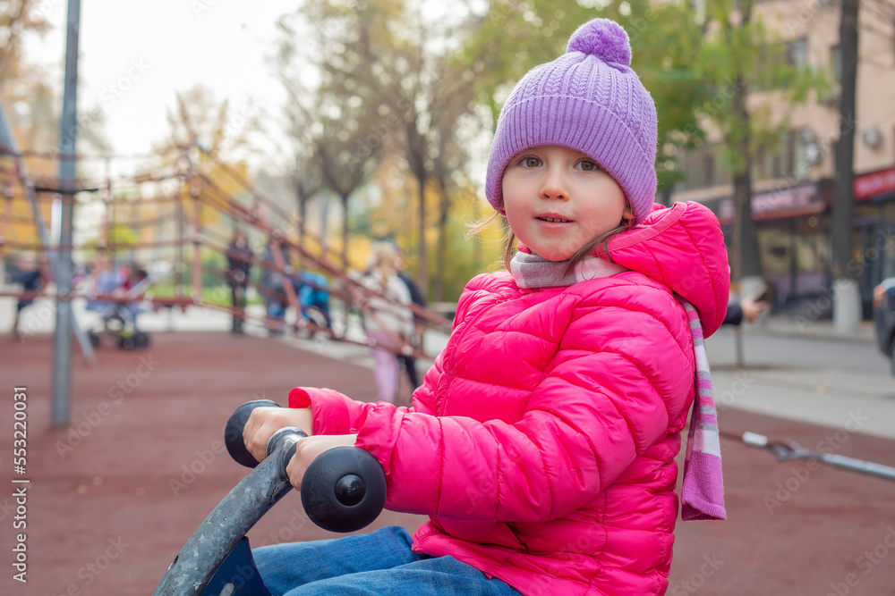Little girl sitting on a wooden swing Little girl sitting on a wooden swing