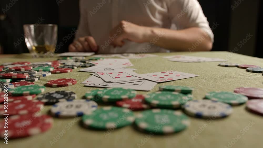 poker player nervously throws playing cards on the green poker table. lose everything at cards poker player nervously throws playing cards on the green poker table. lose everything at cards