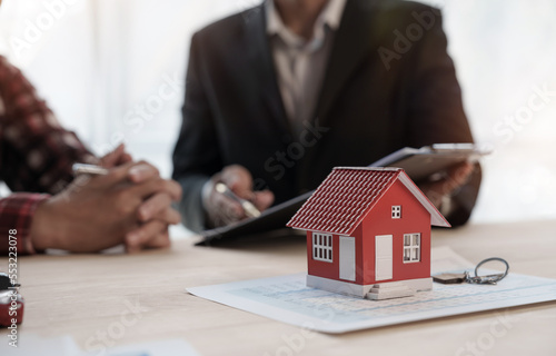 Reading a contract, Credit approver, businessman in male suit and house toy model mockup Home loan mortgage approval concept. After signing the contract