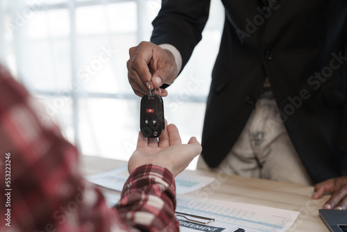 Loan approver, businessman in suit, man giving car keys after car loan approval and contract signing photo