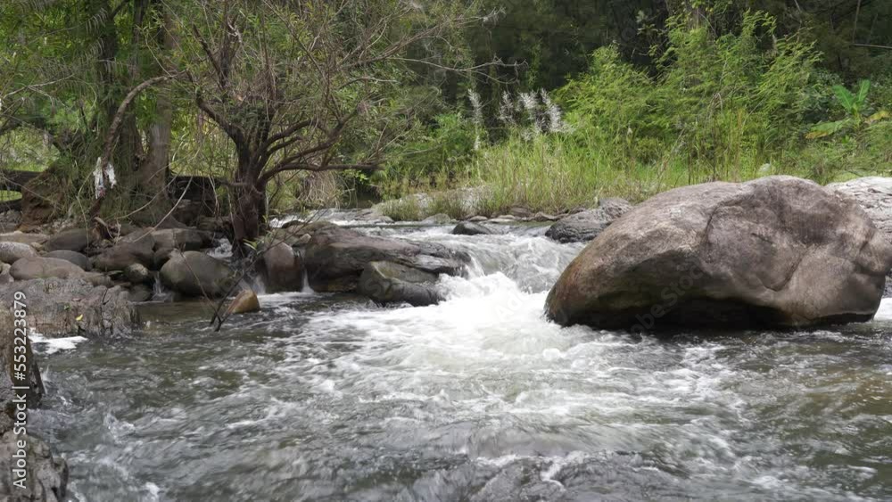 Waterfall stream flows through rocks and green moss. Quiet natural movement, beautiful travel scenery. Waterfall stream flows through rocks and green moss. Quiet natural movement, beautiful travel scenery.