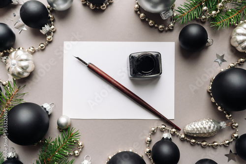 set of vintage dip pen, inkpot and blank paper sheet with envelope on white wooden table photo