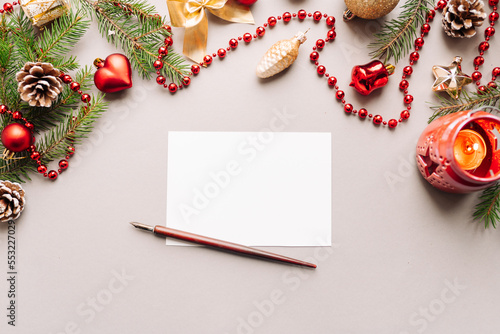 set of vintage dip pen, inkpot and blank paper sheet with envelope on white wooden table, Christmas decoration photo