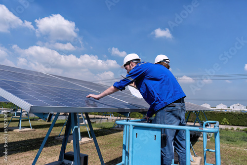 Maintenance engineer at solar farm stand on scissor lift routine inspection solar panel condition