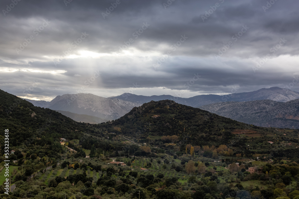Farms and green fields with Mountain Landscape Background. Near Dorgali, Sardinia, Italy. Farms and green fields with Mountain Landscape Background. Near Dorgali, Sardinia, Italy.