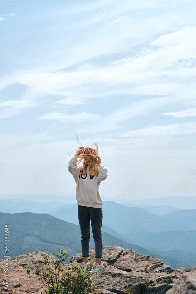 Obraz premium Girl enjoy scenics view on valley. Beautiful nature landscape in mountains. Hiking journey on tourist trail. Outdoor adventure. Travel and exploration. Healthy lifestyle, leisure activities