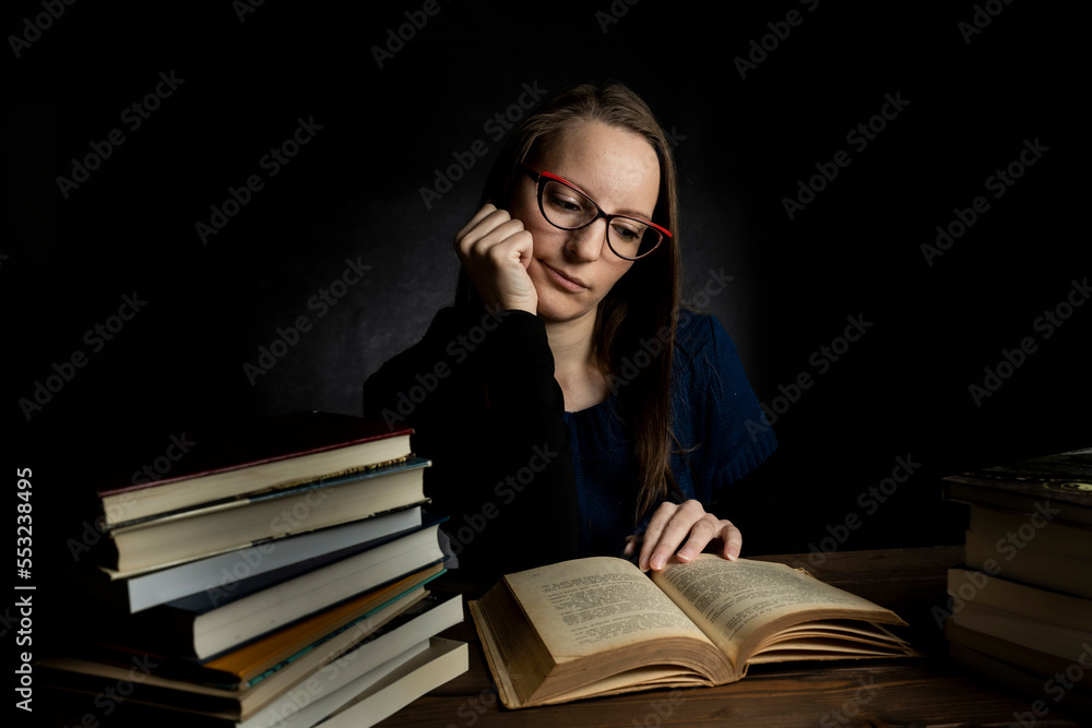 Portrait of a young woman in a studio with a dark background. Portrait of a young woman in a studio with a dark background.