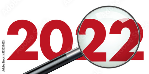 Concept de présentation d’un bilan d’entreprise pour l’année 2022 qui est vu au travers d’une loupe pour symboliser le travail d’analyse.