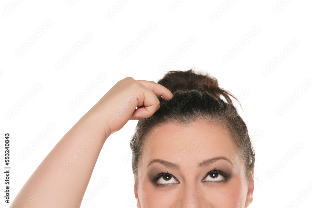 half portrait of a young chubby woman looking up and sctratching her head on a white background. half portrait of a young chubby woman looking up and sctratching her head on a white background.