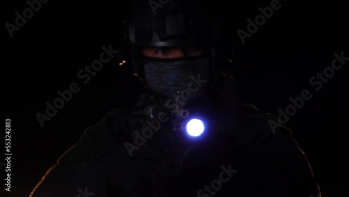 Police officer holding a gun with anti-terrorism mission at night photo