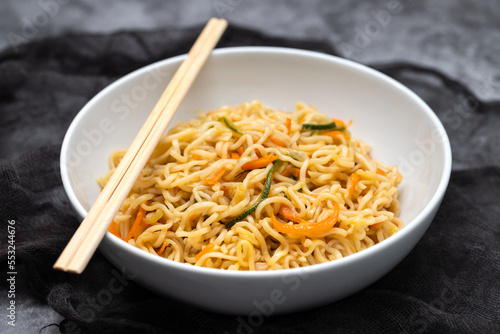 Fresh tasty noodles with vegetables in white bowl