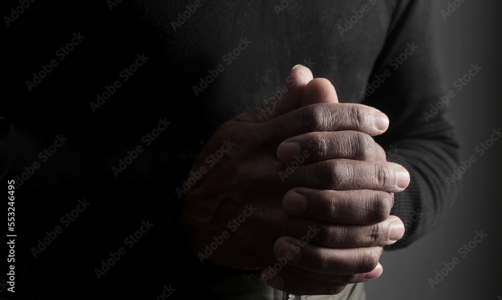 man praying to god with hands together Caribbean man praying with black background stock photo man praying to god with hands together Caribbean man praying with black background stock photo