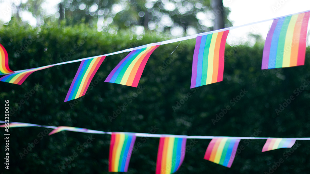 Obraz premium Closeup of gay PRIDE with heart shaped rainbow flag on wrist. Rainbow tattoo. LGBTQ pride month symbol. Equal rights.