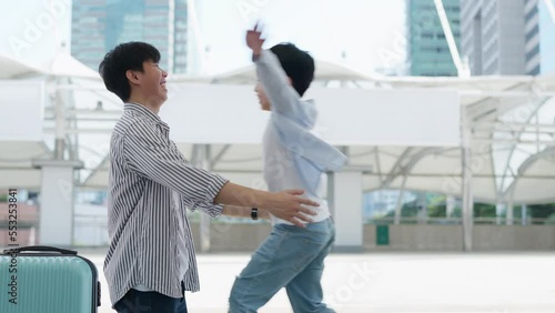 Asia little boy running and hug his father at the airport sky walk with smile on sunny day. Happy for traveling trip during vacation. Family relation father and son. Travel at the central city