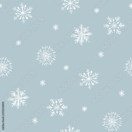 Winter seamless pattern of snowflakes. White snowflakes on gray background.