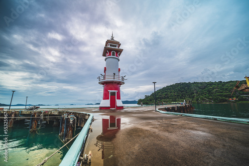 Bang Bao Lighthouse with cloudy sky and reflection in the water at koh chang trat thailand.Lighthouse on a bang bao pier on koh chang island. photo