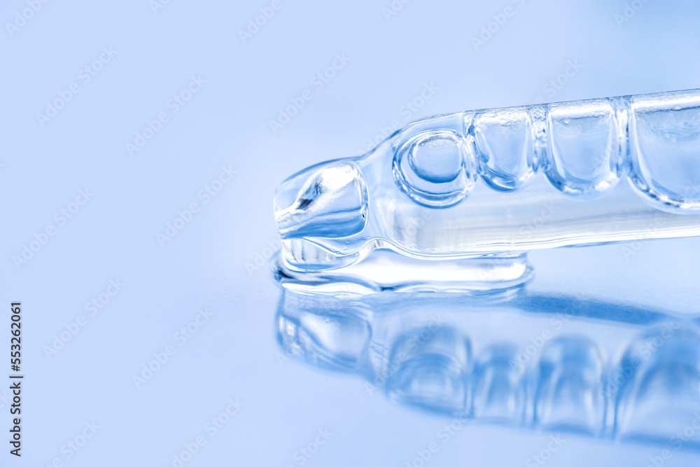 Cosmetic liquid and glass pipette close-up on a blue background. Macro photography, side view, space for text. Cosmetic liquid and glass pipette close-up on a blue background. Macro photography, side view, space for text.