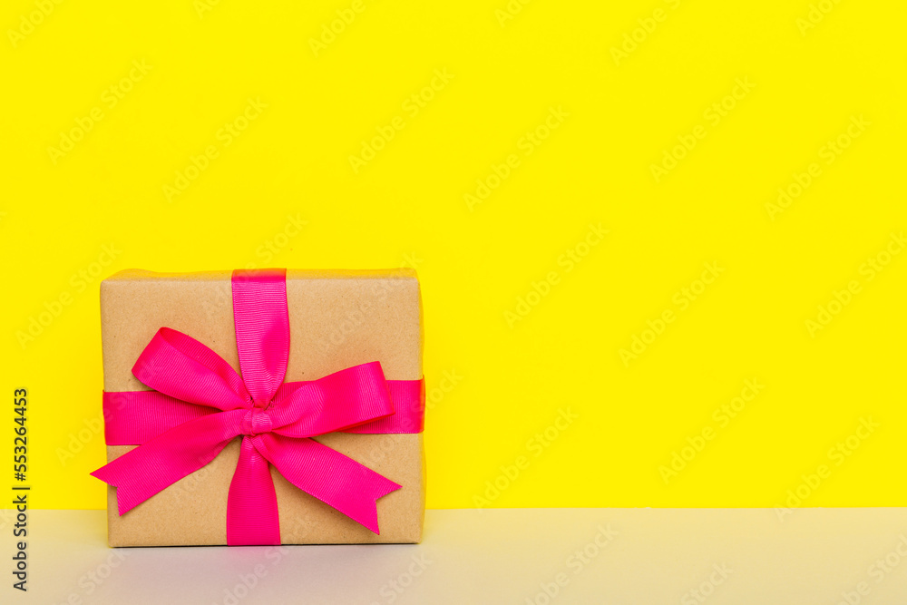 holiday paper present tied pink ribbon bow top view with copy space. Flat lay holiday background. Birthday or christmas present. Christmas gift box concept with copy space holiday paper present tied pink ribbon bow top view with copy space. Flat lay holiday background. Birthday or christmas present. Christmas gift box concept with copy space