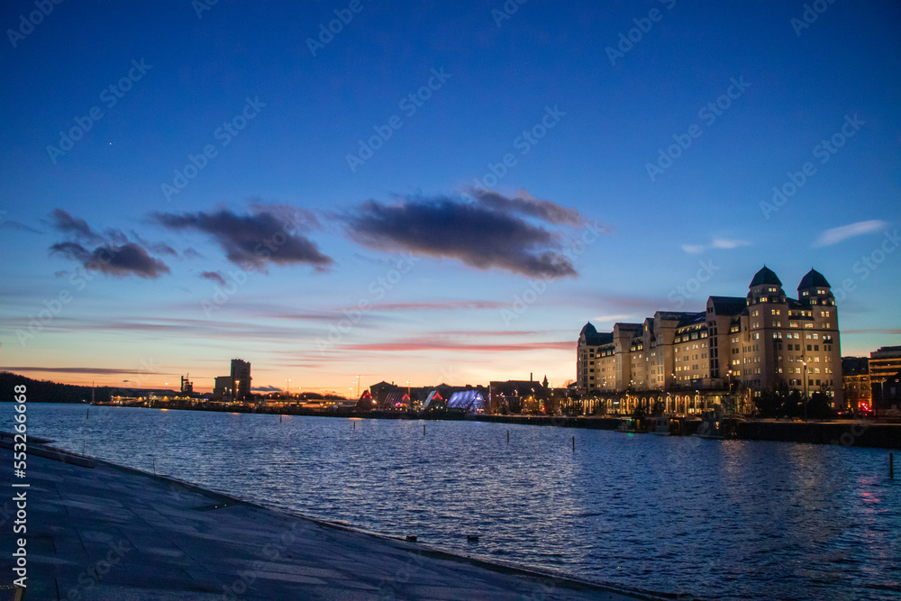 City of Oslo Norway in the Evening with Sunset, Sea, Historical buildings and Christmas decorations City of Oslo Norway in the Evening with Sunset, Sea, Historical buildings and Christmas decorations