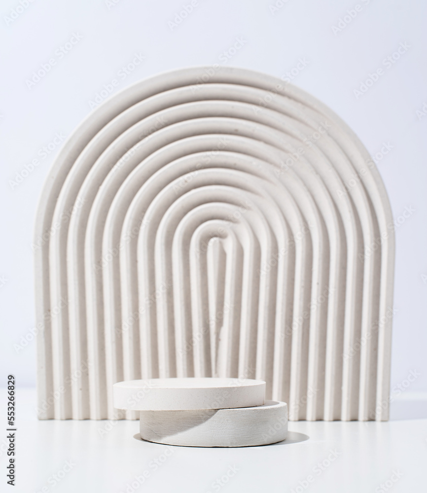 Fototapeta premium A minimalistic scene of a gypsum podium with stones on white background, for natural cosmetics