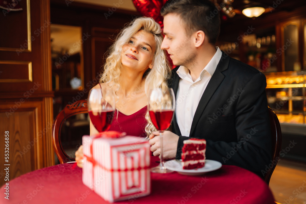 Young couple having a romantic dinner and toasting with glass of red wine. Valentine's Day concept. Relationship, surprise and love concept. Young couple having a romantic dinner and toasting with glass of red wine. Valentine's Day concept. Relationship, surprise and love concept.