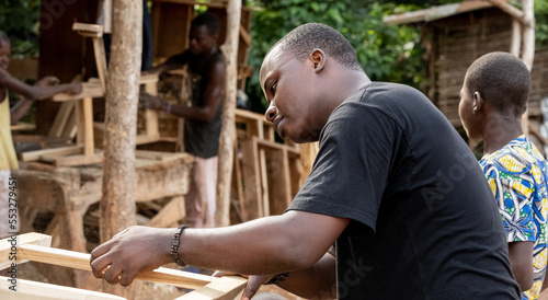 Portrait of a young African man, works in a professional carpentry workshop.