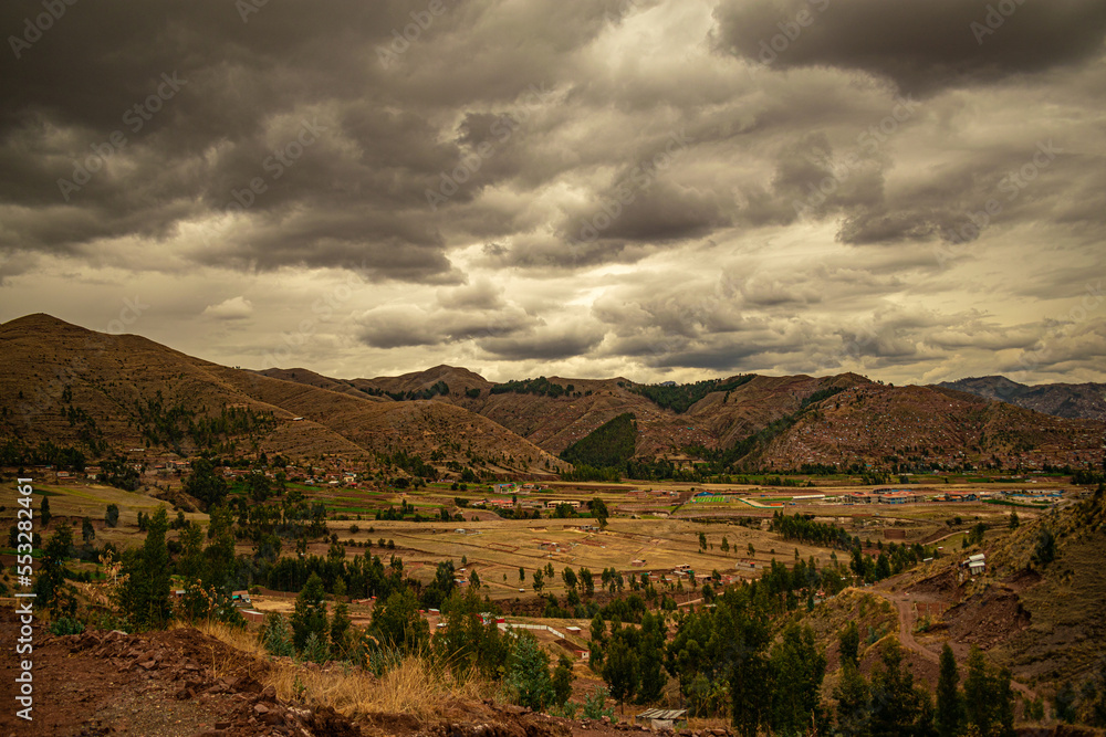 Naklejka premium trees near mountains with cloudy sky in the background in cusco, peru