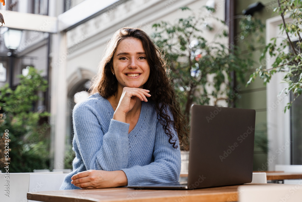 Distance learning. Attractive girl typing and chatting on laptop outdoor in cafe. Concentrated English teacher with laptop have online lesson via video communication outside. Distance learning. Attractive girl typing and chatting on laptop outdoor in cafe. Concentrated English teacher with laptop have online lesson via video communication outside.