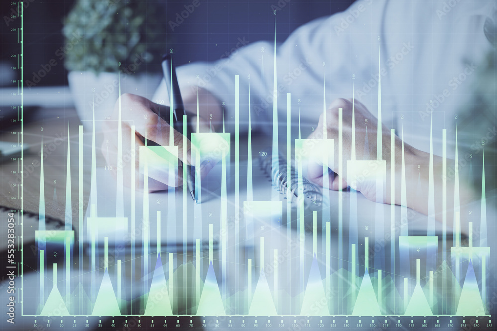 Financial forex graph displayed on hands taking notes background. Concept of research. Double exposure