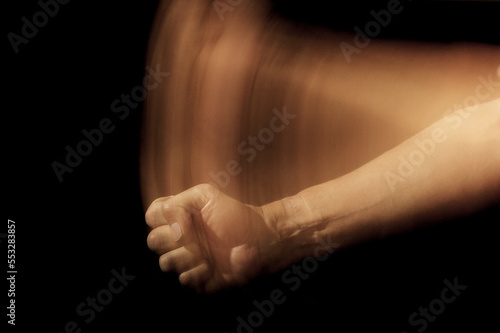 Fist and forearm with trail of tilting movement simulating a blow on the table