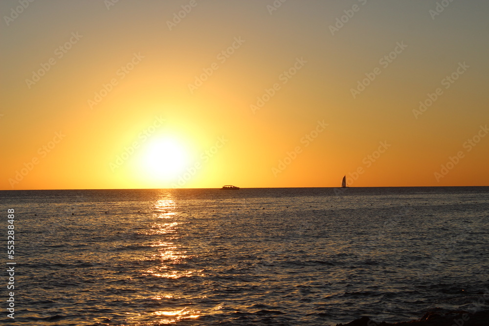 Fototapeta premium Sunset over the sea with boats