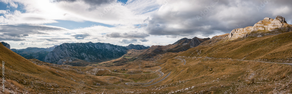 Mountain panorama with rocks, clouds and yellow grass